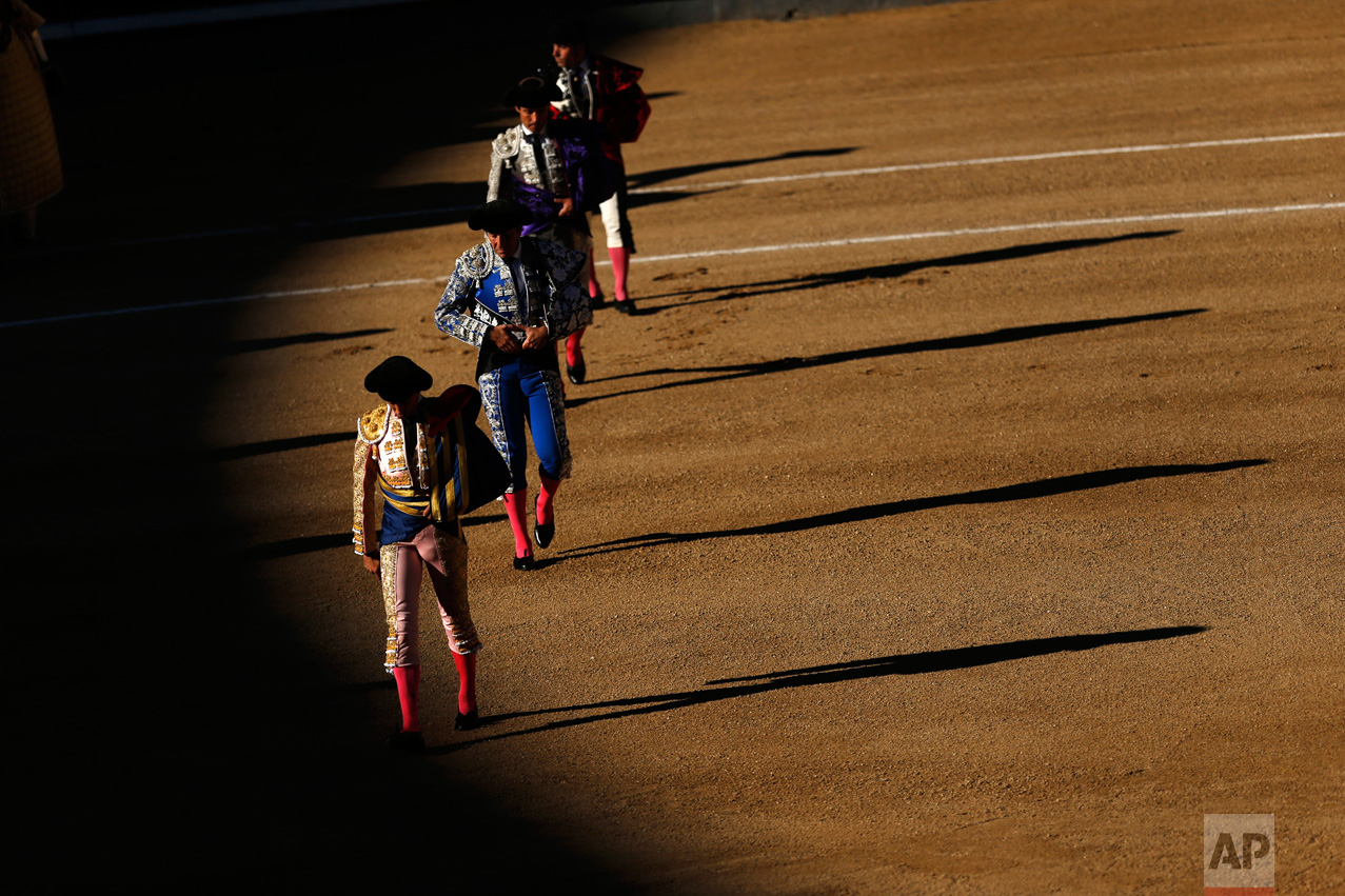 Bullfighters and assistants walk along the ring during the "paseillo" (ritual entrance) to the arena before a bullfight at the Las Ventas bullring in Madrid, Thursday, May 18, 2017. (AP Photo/Francisco Seco)
