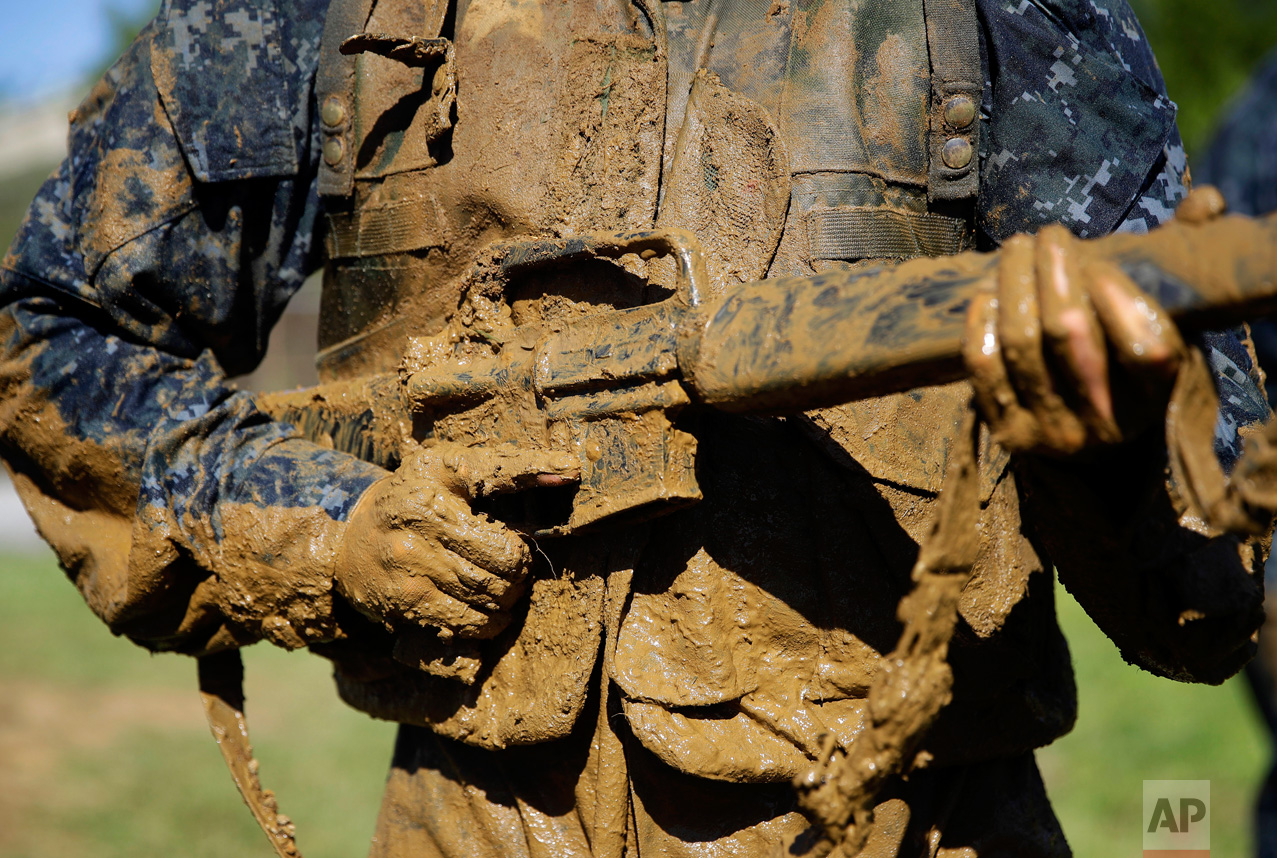  A first-year midshipman, known as a "plebe," carries a dummy rifle covered in mud during Sea Trials, a day-long training exercise that caps off their plebe year at the U.S. Naval Academy in Annapolis, Md., Tuesday, May 16, 2017. (AP Photo/Patrick Se