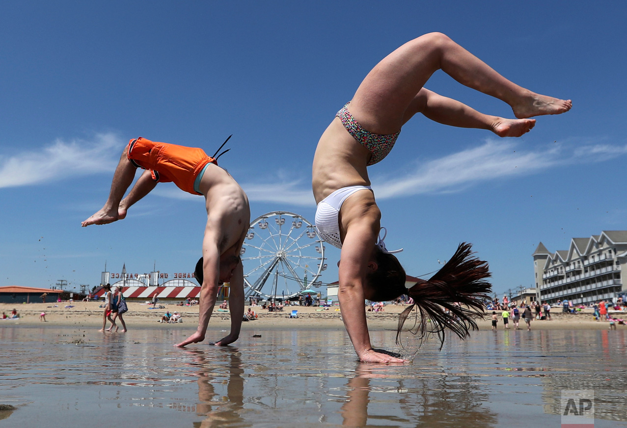  Dan Copeland, left, and Alex Morneau of Biddeford, Maine, former high school cheerleaders, perform back flips during record-breaking heat, Thursday, May 18, 2017, at Old Orchard Beach, Maine. The temperature climbed into the 90s in many locations th