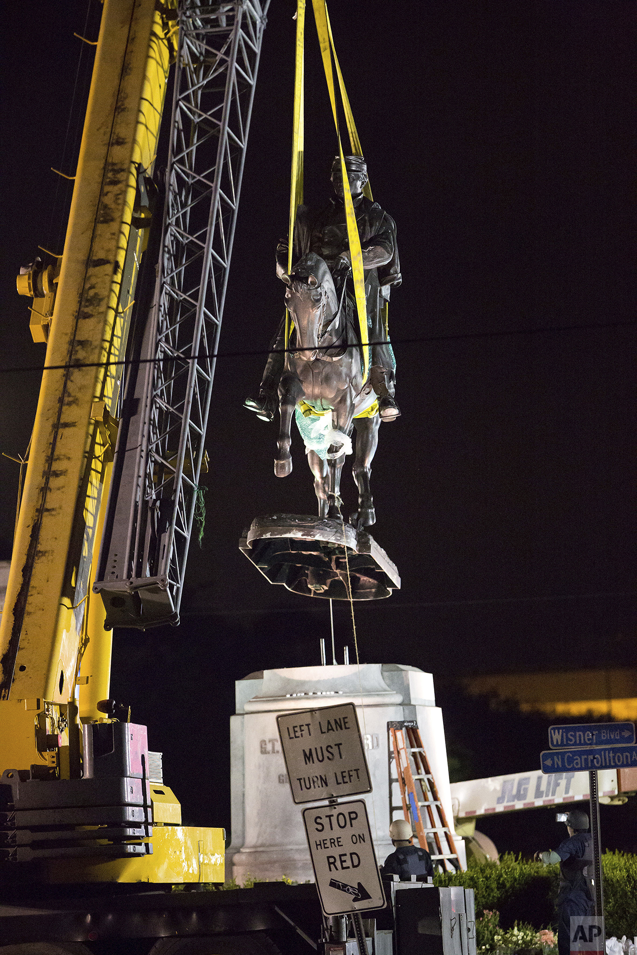 A statue of Confederate Gen. P.G.T. Beauregard is removed from the entrance to City Park in New Orleans, just after 3 a.m. Wednesday, May 17, 2017. The removal of the statue comes after the city has already taken down a statue of Jefferson Davis, the Confederacy's only president, and a memorial to a white rebellion against a biracial Reconstruction-era government in the city. (AP Photo/Scott Threlkeld)