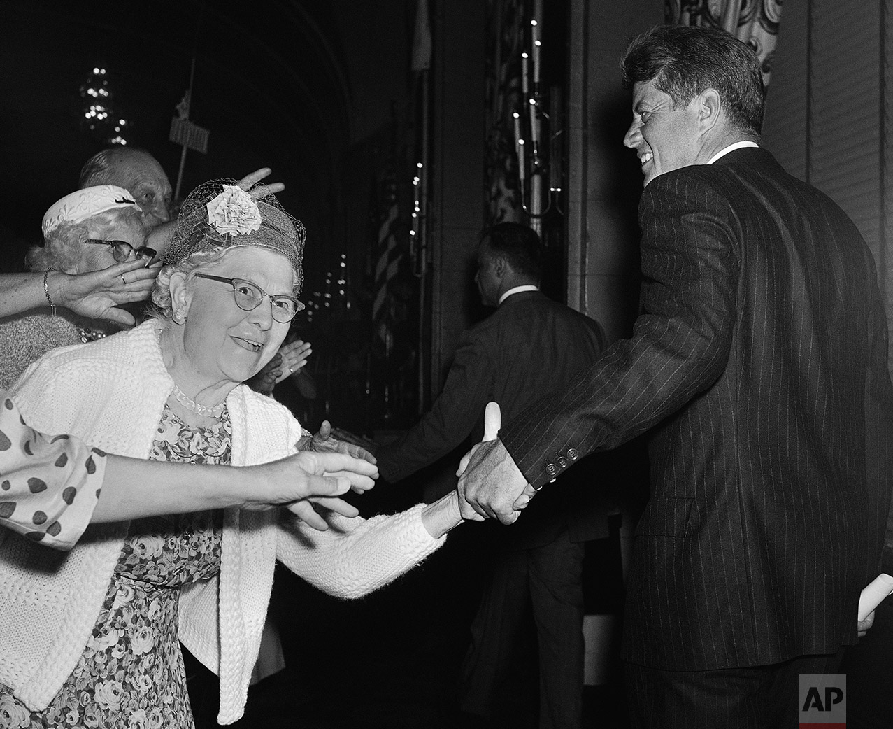  Reaching hands engulf President John Kennedy's right hand and coat sleeve June 13, 1963 after he addressed a meeting in Washington of the National Council of Senior Citizens.     Kennedy  told the council that "it's time the United States caught up"