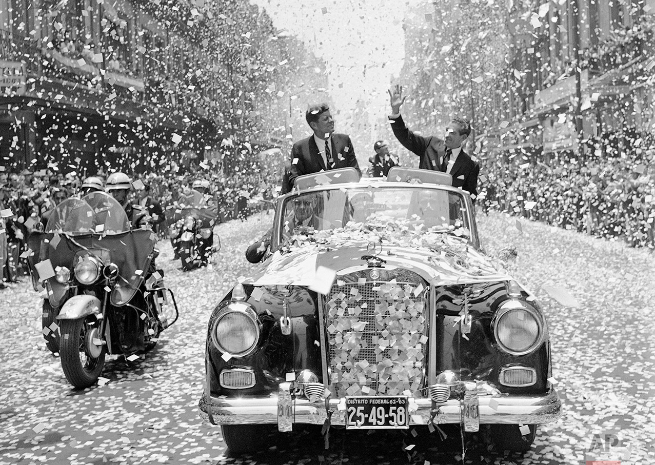  U.S. President John F. Kennedy and Mexican President Adolfo Lopez Mateos are showered with tons of confetti and paper, June 29, 1962, as they travel down one of Mexico City’s boulevards shortly after Kennedy’s arrival for a three-day visit. (AP Phot