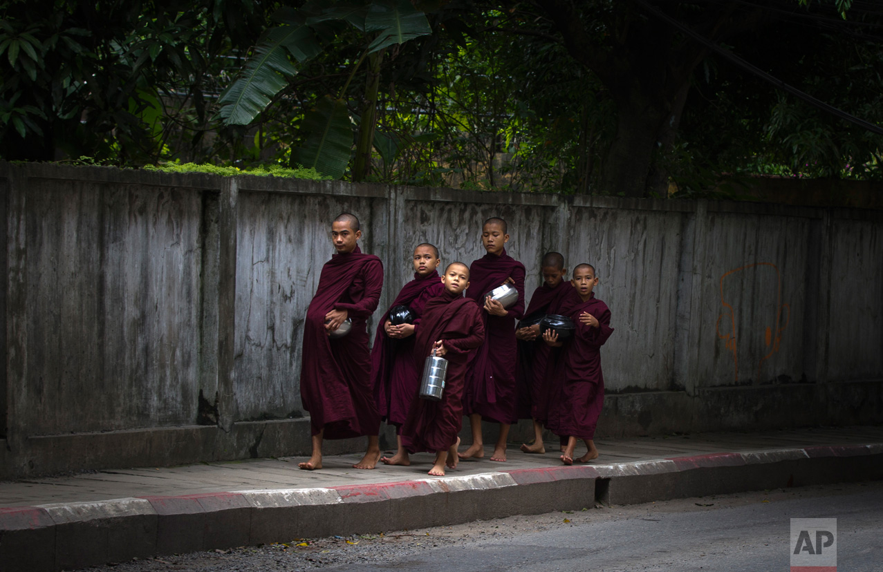  Buddhist monks walk to collect their morning "alms" (offerings) in Yangon, Myanmar, on Friday, June 16, 2017. (AP Photo/Thein Zaw) 