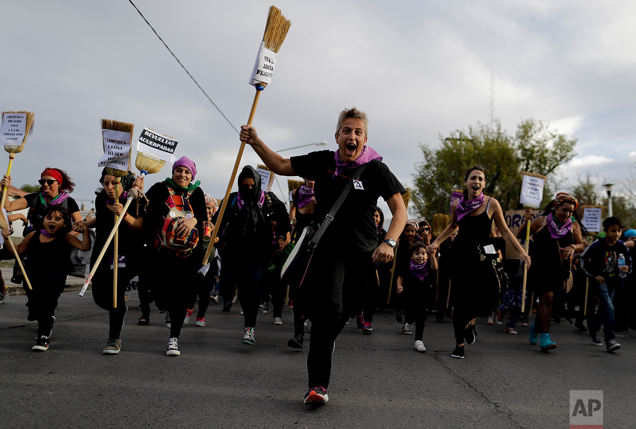  In this March 8, 2017 photo, women run with brooms during an International Women's Day march in Neuquen, Argentina. This year, the "Ni Una Menos" movement to protest violence against women helped organize a strike for International Women’s Day on Ma
