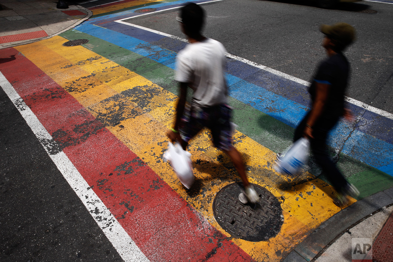  In this June 17, 2016, photo, people walk across a rainbow crosswalk painted in support of the LGBT community in the Gayborhood, a gay-friendly section of Philadelphia. The Philadelphia Commission on Human Relations recommended Monday, Jan. 23, 2017