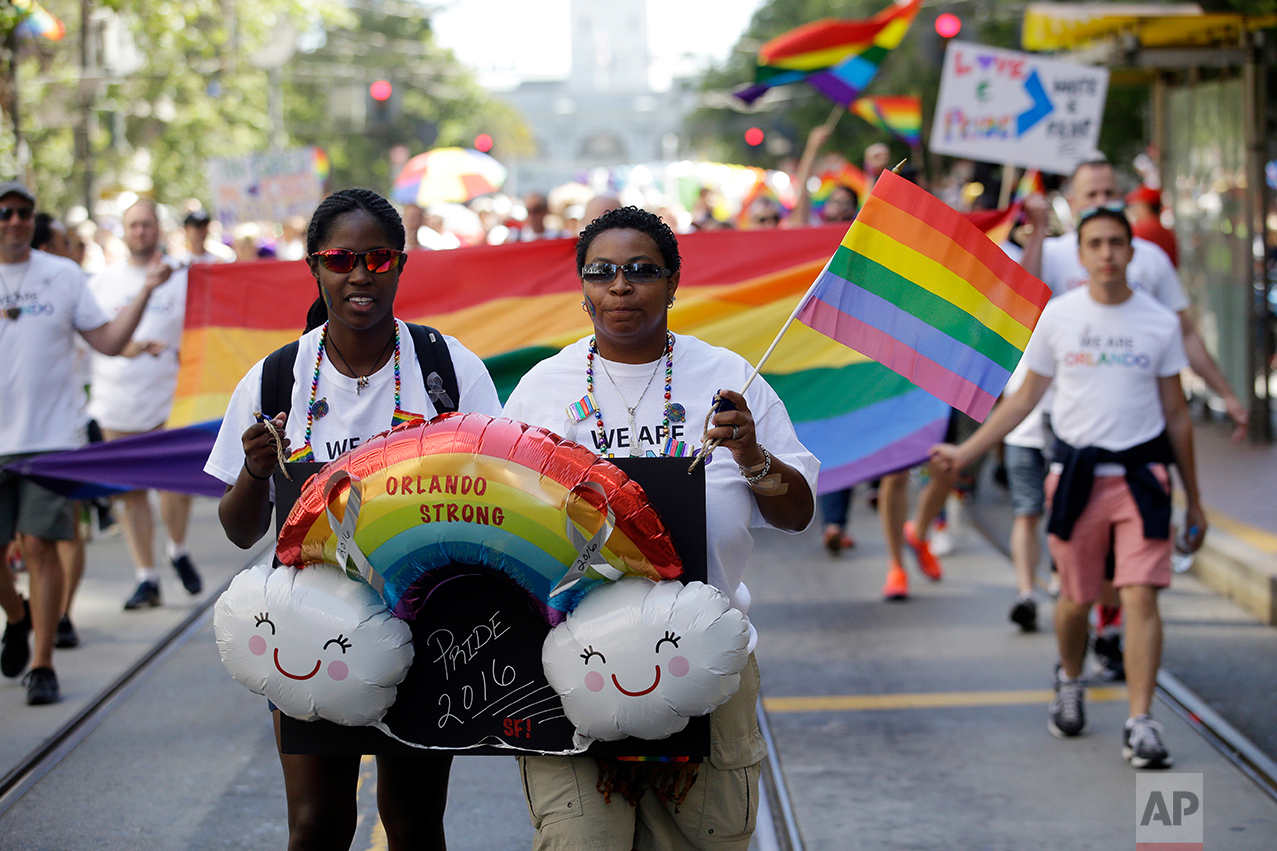  Chanta Anderson, right, and Ashlee Stephens hold signs in memory of the Orlando nightclub shooting during the San Francisco Gay Pride parade Sunday, June 26, 2016, in San Francisco. (AP Photo/Marcio Jose Sanchez) 