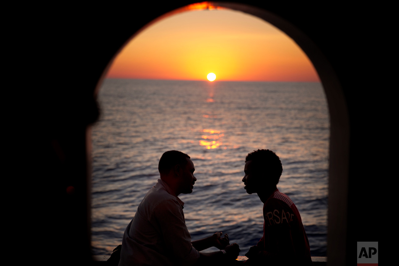 Two men from Sudan talk on the deck of the Golfo Azzurro rescue ship, after being rescued from a rubber boat out of control near the Libyan coast, on Thursday, June 22, 2017. (AP Photo/Emilio Morenatti)