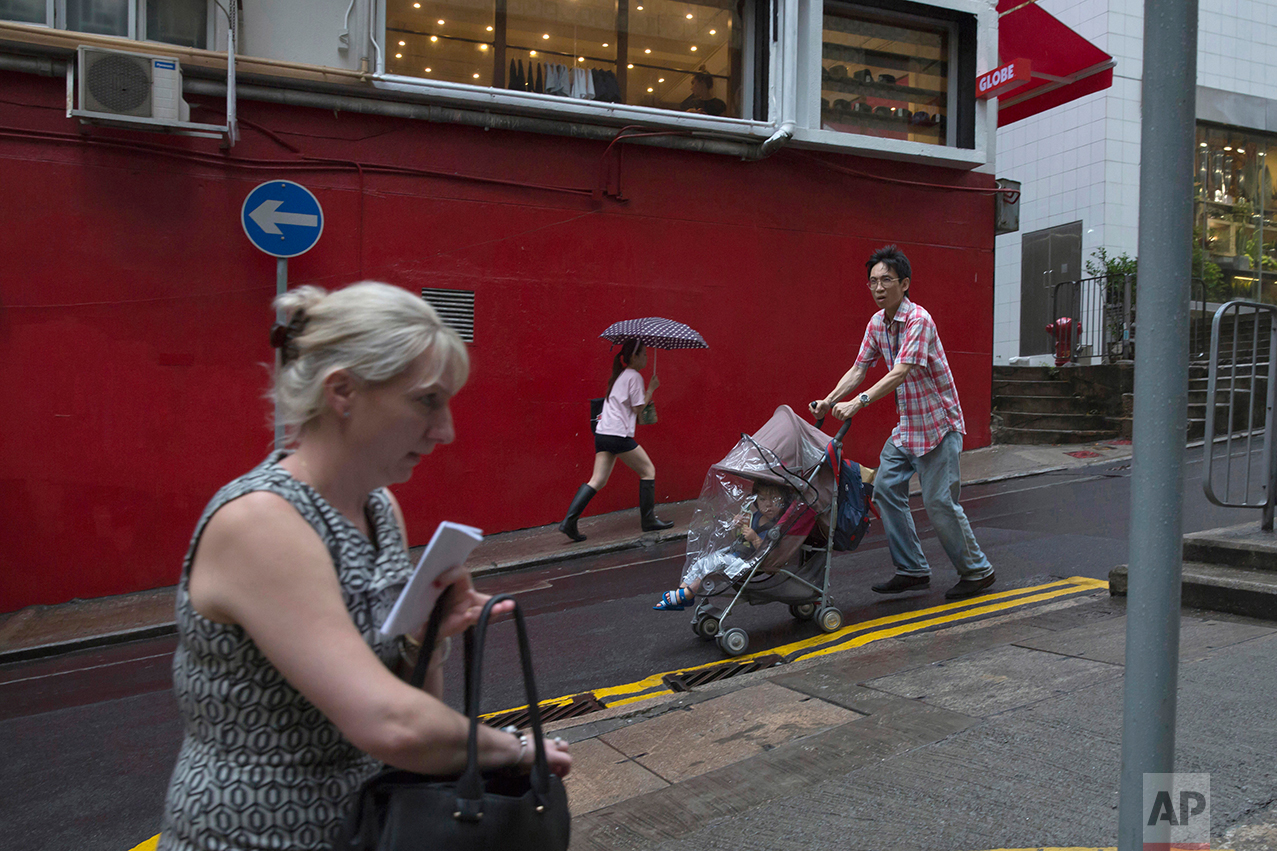 In this June 12, 2017, photo, people walk on the slope in Central district, Hong Kong. (AP Photo/Kin Cheung)
