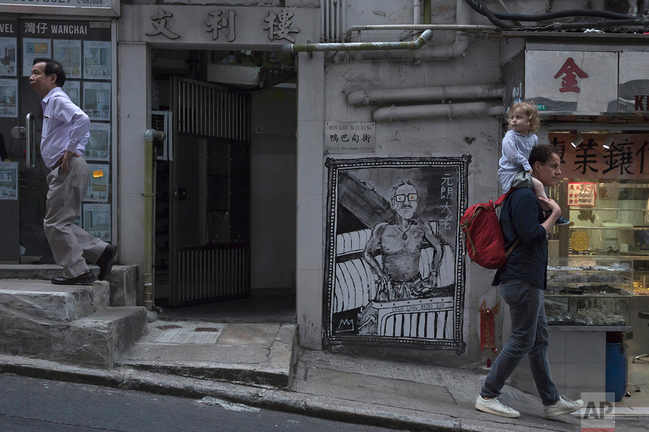 In this May 20, 2017, photo, people walk on the slope in Central district, Hong Kong. (AP Photo/Kin Cheung)