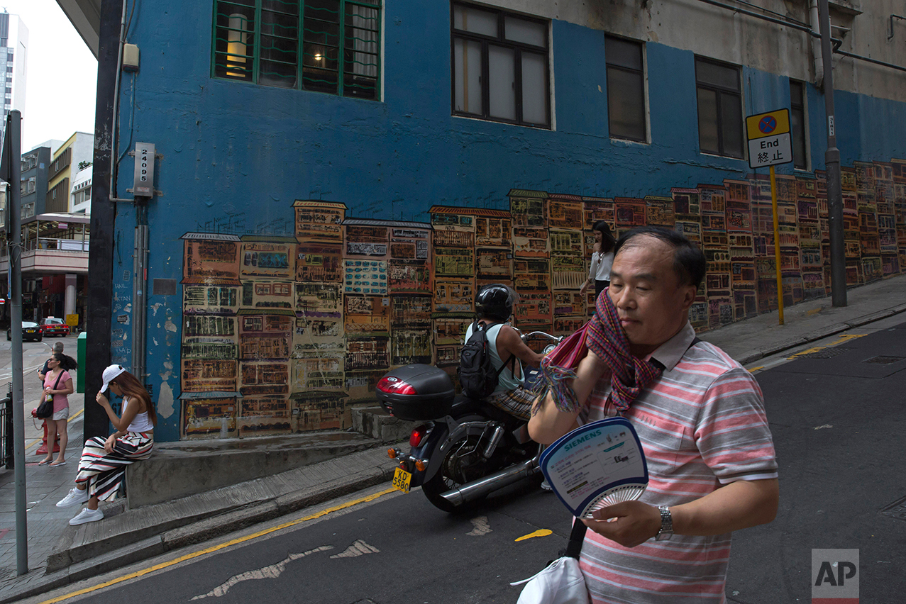 In this June 4, 2017, photo, a man walks down the slope in Central district, Hong Kong. (AP Photo/Kin Cheung)