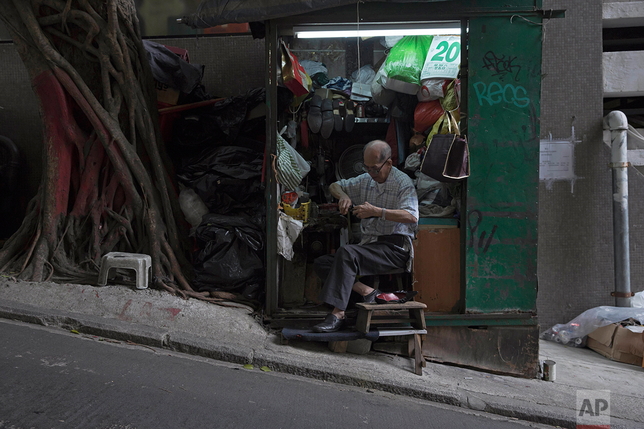 In this May 20, 2017, photo, a man fixes shoes at his shop on the slope in Central district, Hong Kong. (AP Photo/Kin Cheung)