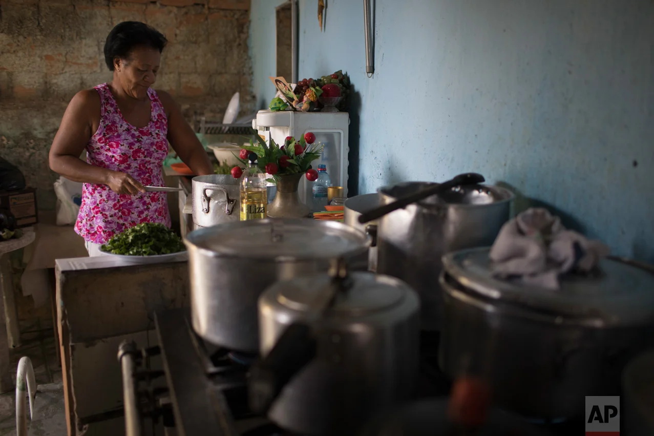 In this June 12, 2017 photo, Ana Regina de Jesus cooks in the City of God slum of Rio de Janeiro, Brazil. (AP Photo/Leo Correa)