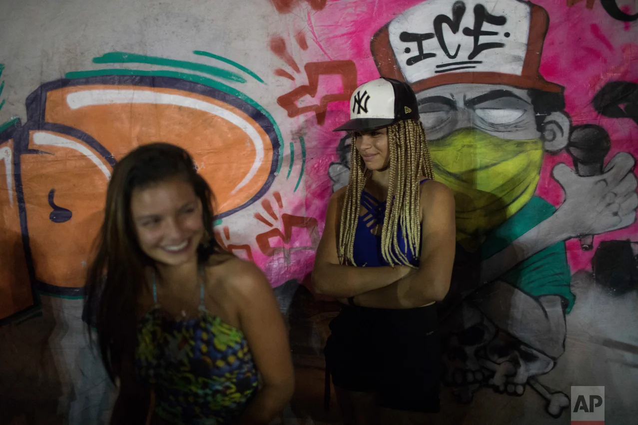 In this June 8, 2017 photo, young women attend a night session of rap battles in the City of God slum of Rio de Janeiro, Brazil. (AP Photo/Leo Correa)