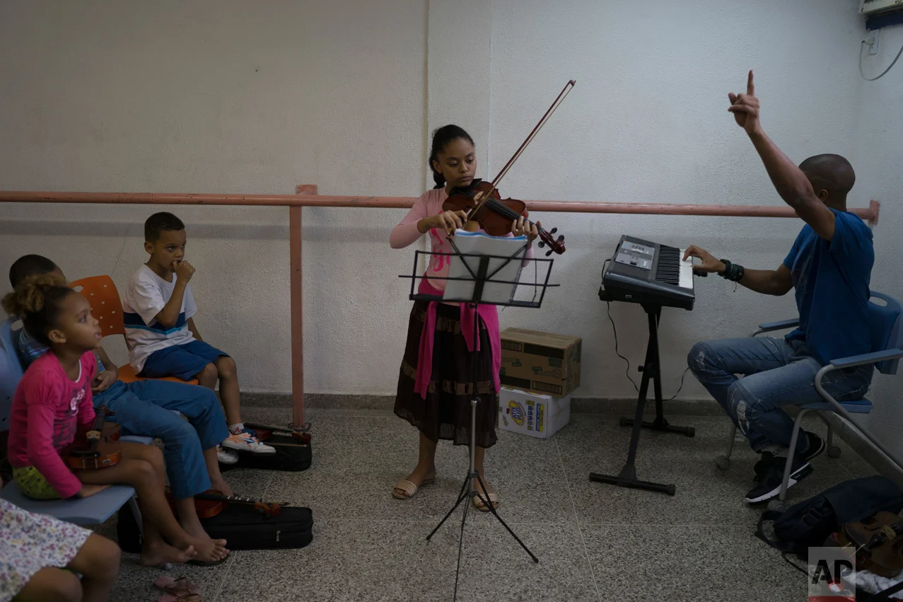 In this June 5, 2017 photo, Isabela Maia plays the violin during class in the City of God slum of Rio de Janeiro, Brazil. (AP Photo/Leo Correa)