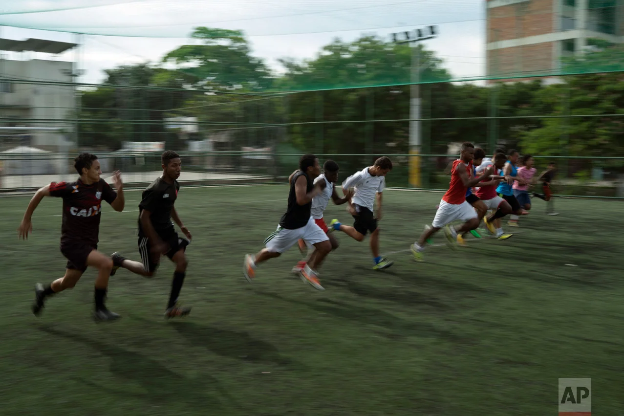 In this June 5, 2017 photo, youth warm up for soccer practice in the City of God slum of Rio de Janeiro, Brazil. (AP Photo/Leo Correa)
