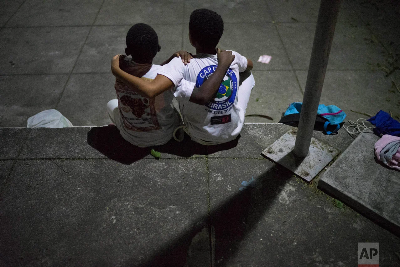 In this June 5, 2017 photo, boys embrace as they take a time-out from their Copeira class, assigned to them as a punishment for arguing, at a community center in the City of God slum in Rio de Janeiro, Brazil. (AP Photo/Leo Correa)