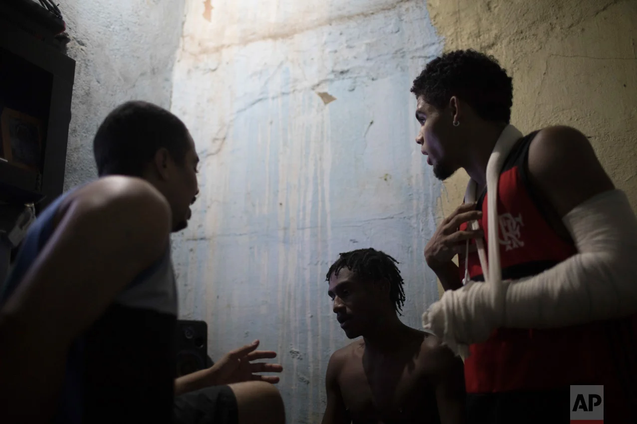 In this June 8, 2017 photo, Lucas dos Santos da Cruz, 18, center, talks with friends about the night's upcoming rap battle in the City of God slum of Rio de Janeiro, Brazil. (AP Photo/Leo Correa)