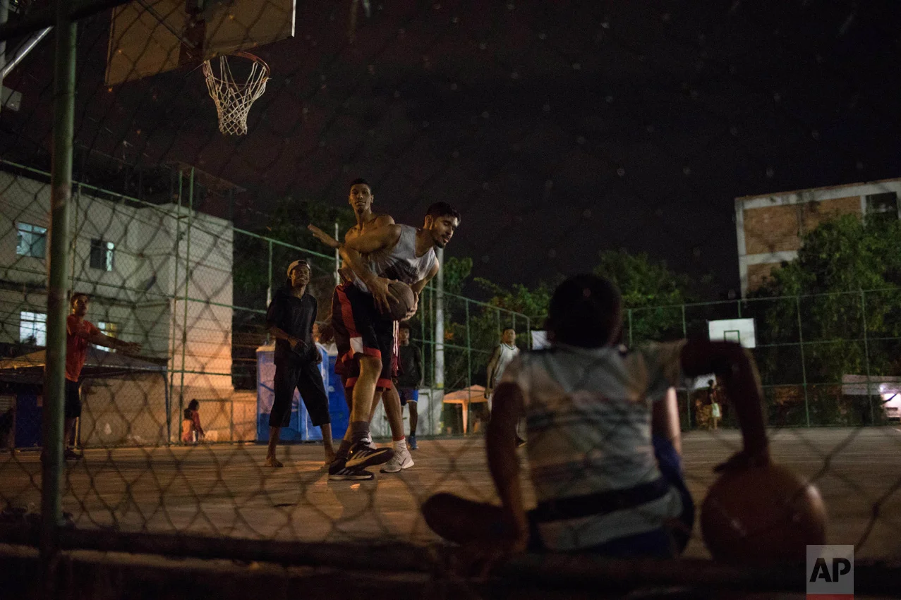 In this June 6, 2017 photo, youth play basketball in the City of God slum of Rio de Janeiro, Brazil. (AP Photo/Leo Correa)