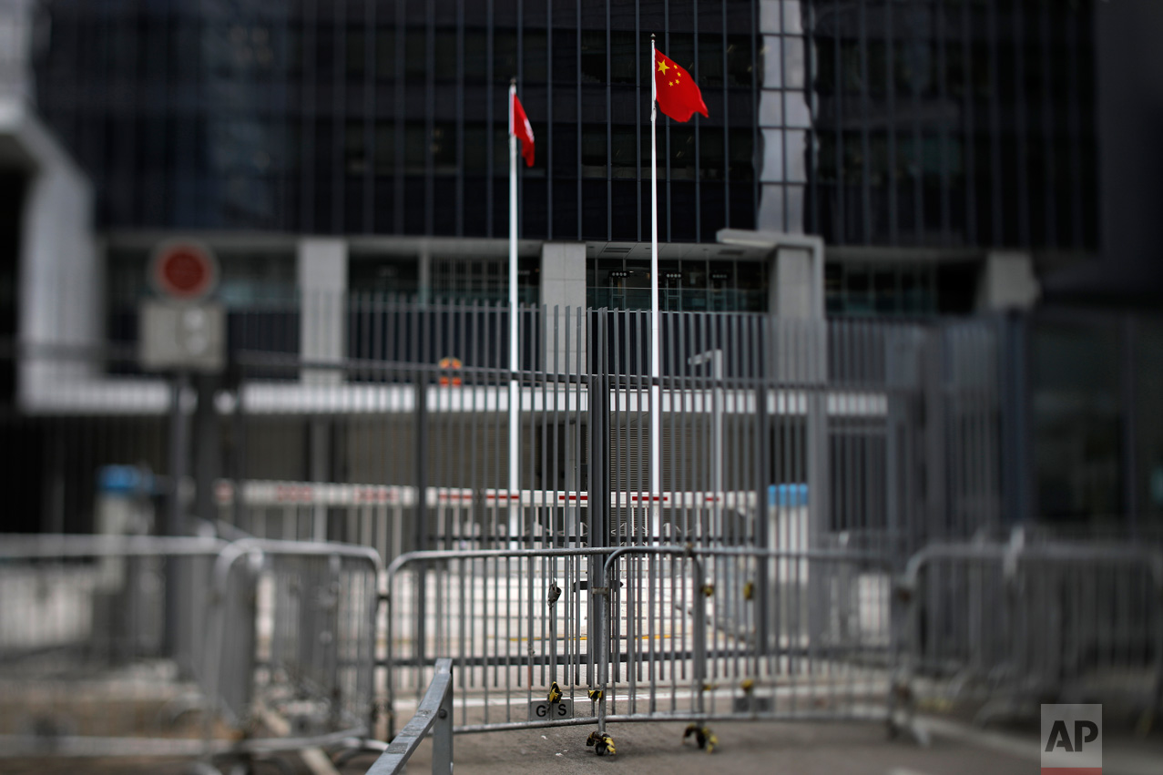 In this June 8, 2017, photo made with a tilt-shift lens, a Chinese national flag and a Hong Kong flag are seen at the East Wing Forecourt of the Central Government Office in Hong Kong. The forecourt, known as Civic Square which is next to Hong Kong's city government headquarters, was fenced off in July 2014, angering activists who said the government had promised to let it be used for demonstrations. Student protesters rushed the courtyard in September 2014, sparking the 79-day "Umbrella Movement" protests. Two decades since Beijing took control of Hong Kong, China's rising influence – and Britain's waning profile – are impossible to ignore. (AP Photo/Vincent Yu)