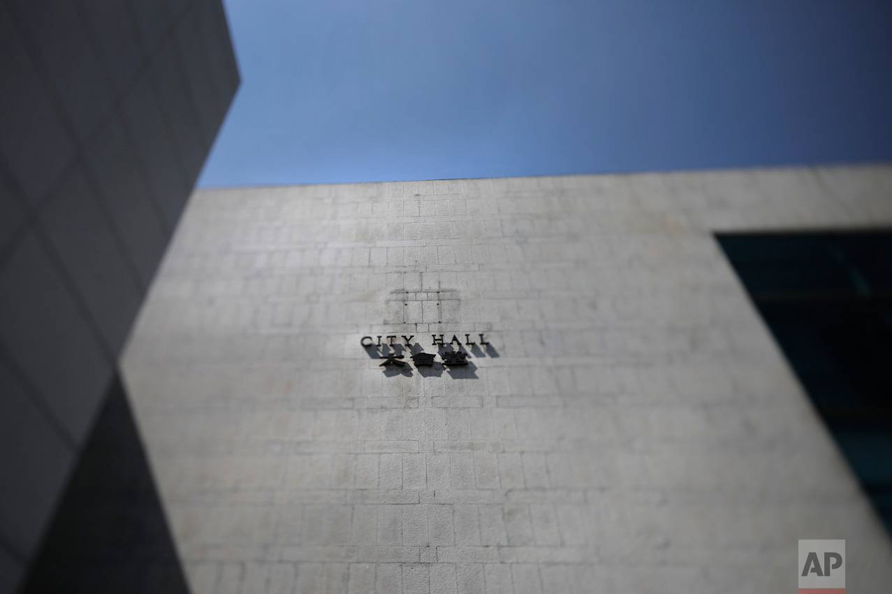 In this May 29, 2017, photo made with a tilt-shift lens, a mark still remains on the wall after the removal of the British colonial emblem at City Hall in Hong Kong. Two decades since Beijing took control of Hong Kong in 1997, China's rising influence – and Britain's waning profile – are impossible to ignore. (AP Photo/Vincent Yu)