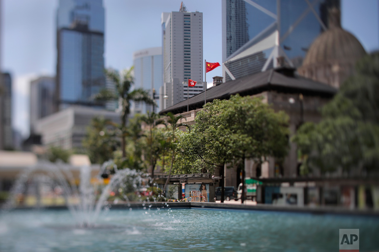 In this May 31, 2017, photo made with a tilt-shift lens, a Chinese national flag and a Hong Kong flag fly at the Court of Final Appeal in Hong Kong. Under the "one country, two systems" principle, Hong Kong retains an independent judiciary, setting it apart from mainland China. (AP Photo/Vincent Yu)