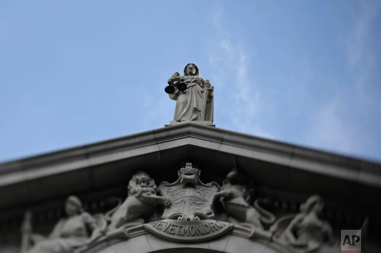 In this May 31, 2017, photo made with a tilt-shift lens, the blind-folded statue of the Greek goddess of justice and law is seen on top of the Court of Final Appeal in Hong Kong. (AP Photo/Vincent Yu)