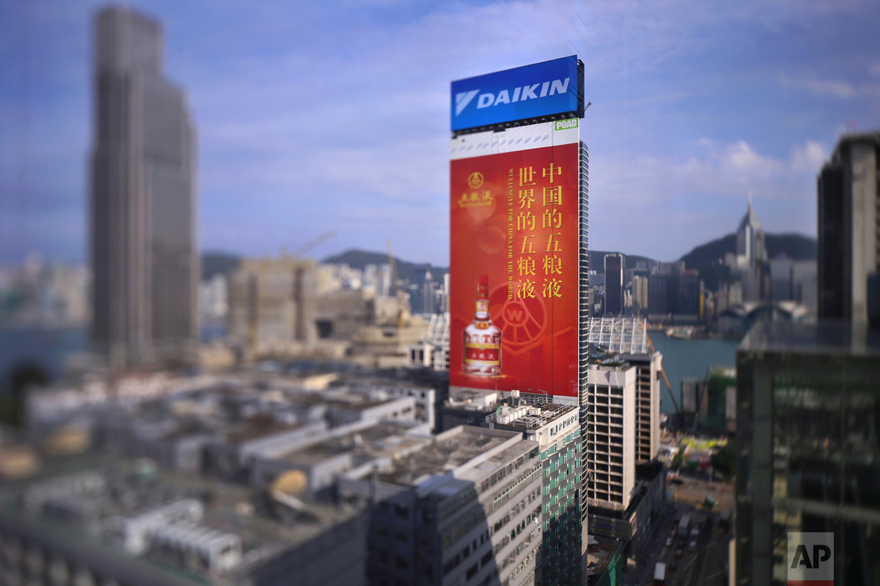 In this May 27, 2017, photo made with a tilt-shift lens, an adverting board of China's best known spirit 'Wuliangye' is seen at the Tsim Sha Tsui district in Hong Kong. The Chinese words read "Wuliangye for China for the world". (AP Photo/Vincent Yu)