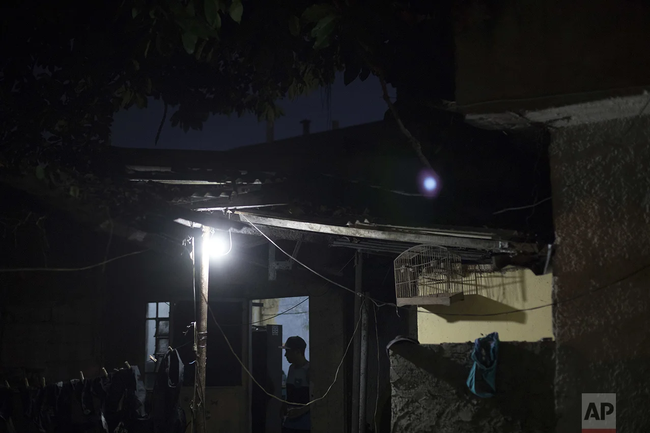 In this June 8, 2017 photo, Erik Franca, 25, stands outside the room where he and his friends produce music in the City of God slum of Rio de Janeiro, Brazil. Soon after they left what they call "the bunker," they went to a poorly illuminated square to compete in freestyle rap battles. (AP Photo/Leo Correa)