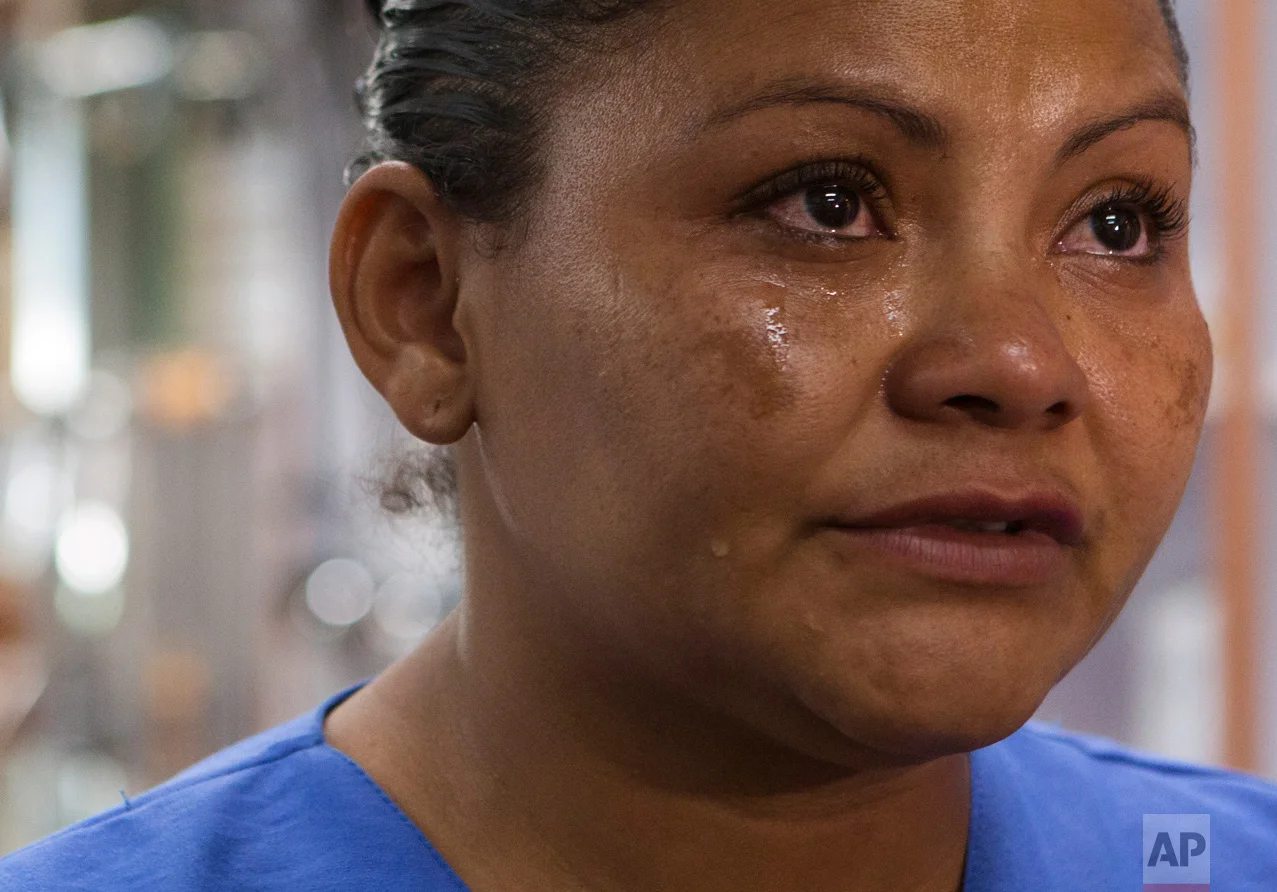 In this June 27, 2017 photo, Laura Maria Cruz Martinez of Honduras cries as she recounts the fear she felt for her children when she, another fellow single mother and the nine kids in their care fled their homes only hours after receiving gang threats, during an interview at the medical supplies store where she now works in the Doctores neighborhood of Mexico City. (AP Photo/Rebecca Blackwell)