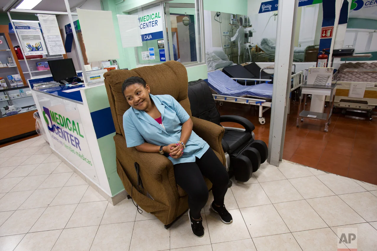 In this June 27, 2017 photo, Honduran refugee Laura Maria Cruz Martinez sits in a display chair as she waits for customers at the medical supplies store where she works in Mexico City. (AP Photo/Rebecca Blackwell)