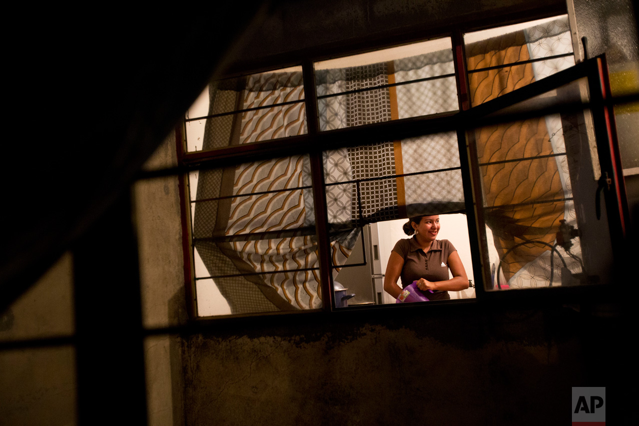 In this June 27, 2017 photo, Emma Karina Cruz Velasquez, 16, of Honduras, prepares dinner for the household in the two-bedroom apartment shared by two refugee families headed by single mothers, in the Iztapalapa district of Mexico City. (AP Photo/Rebecca Blackwell)