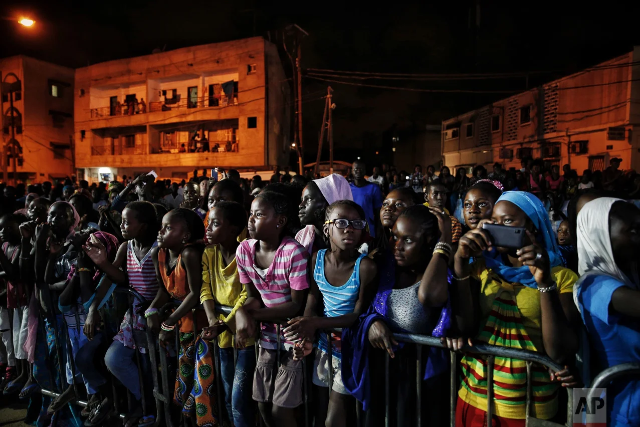 Senegalese youth watch a runway show during Dakar Fashion Week in the capital's Niari Tali neighborhood, Thursday June 29, 2017. (AP Photo/Finbarr O'Reilly)