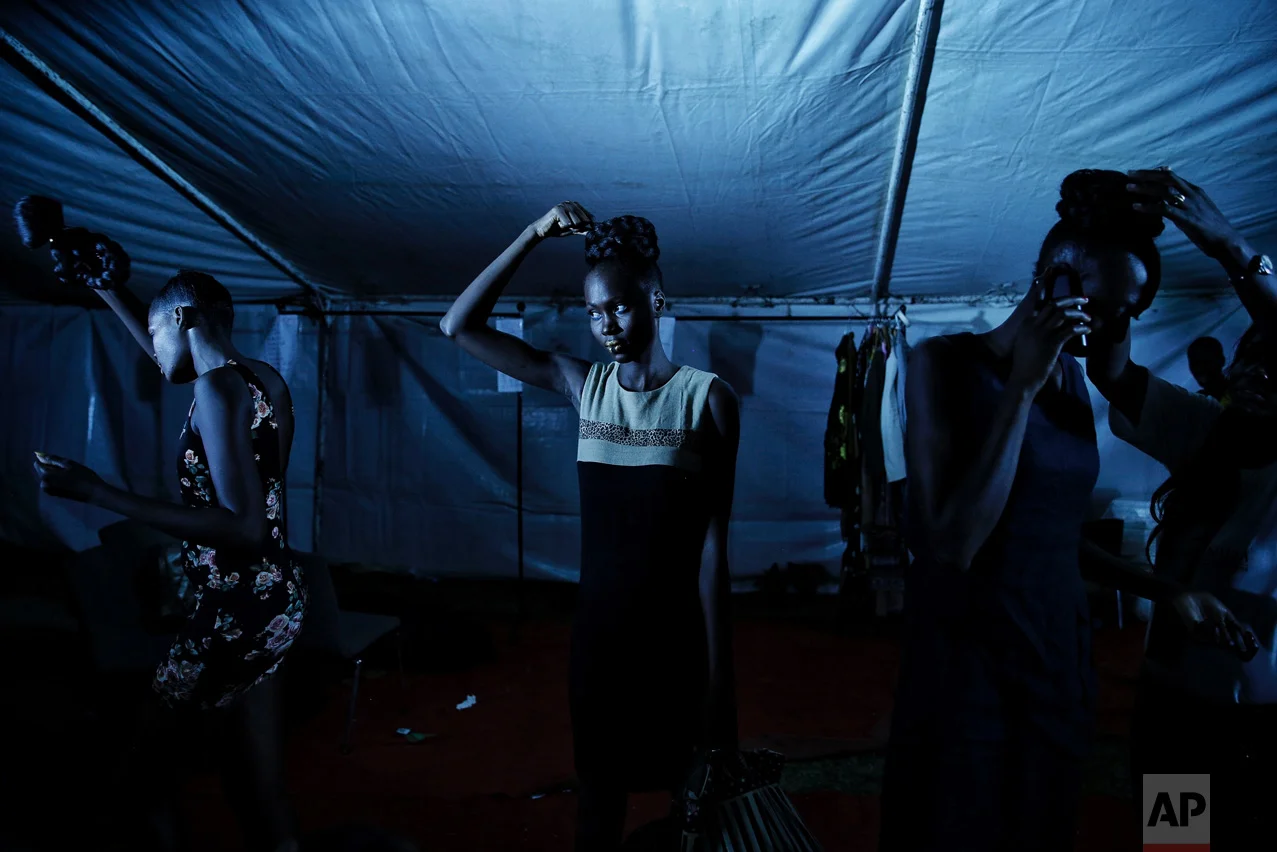 Models remove their wigs after the finale of Dakar Fashion Week in the Senegalese capital, Friday July 1, 2017. (AP Photo/Finbarr O'Reilly)