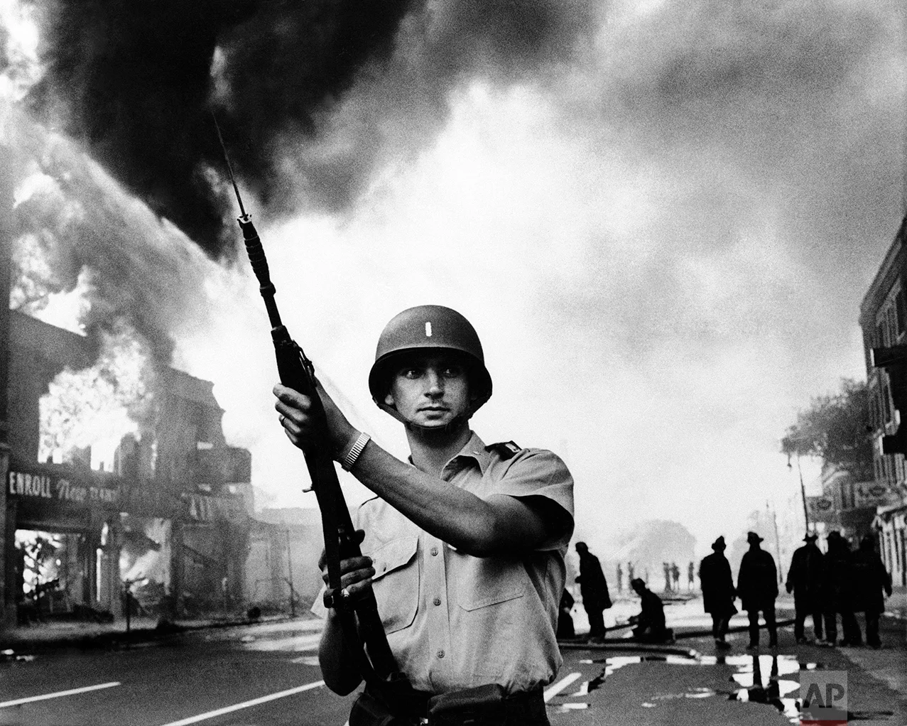 Michigan national guardsmen stood at the ready as firemen battled one of the numerous blazes in riot-torn district of Detroit in July 1967. Riots ripped the motor city following similar demonstrations in New Jersey. (AP Photo)