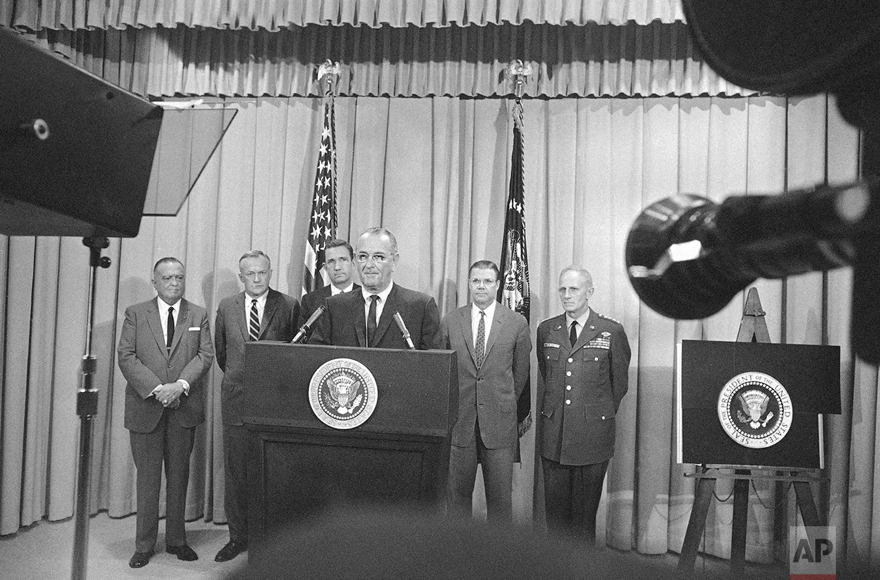 President Lyndon Johnson uses television and radio to explain that Federal troops have been ordered into Detroit to restore law and order. He spoke from the White House in Washington on July 24, 1967. Behind him, from left, are FBI Director J. Edgar Hoover; Secretary of the Army Stanley Resor; Attorney General Ramsey Clark ; Secretary of Defense Robert McNamara; and Gen. Harold Johnson, Army Chief of Staff. (AP Photo/Charles Gorry)