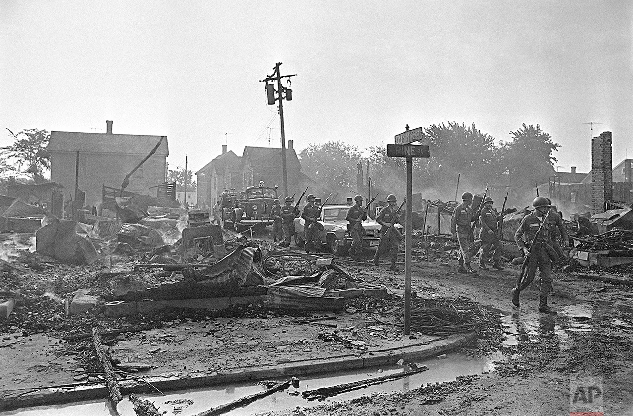 Armed Maryland National Guardsmen precede a fire truck moving into the riot area of Cambridge, Maryland, July 25, 1967 as debris from last night’s fires in a leveled block-long area continued to smolder and burn. (AP Photo/Bob Schutz)