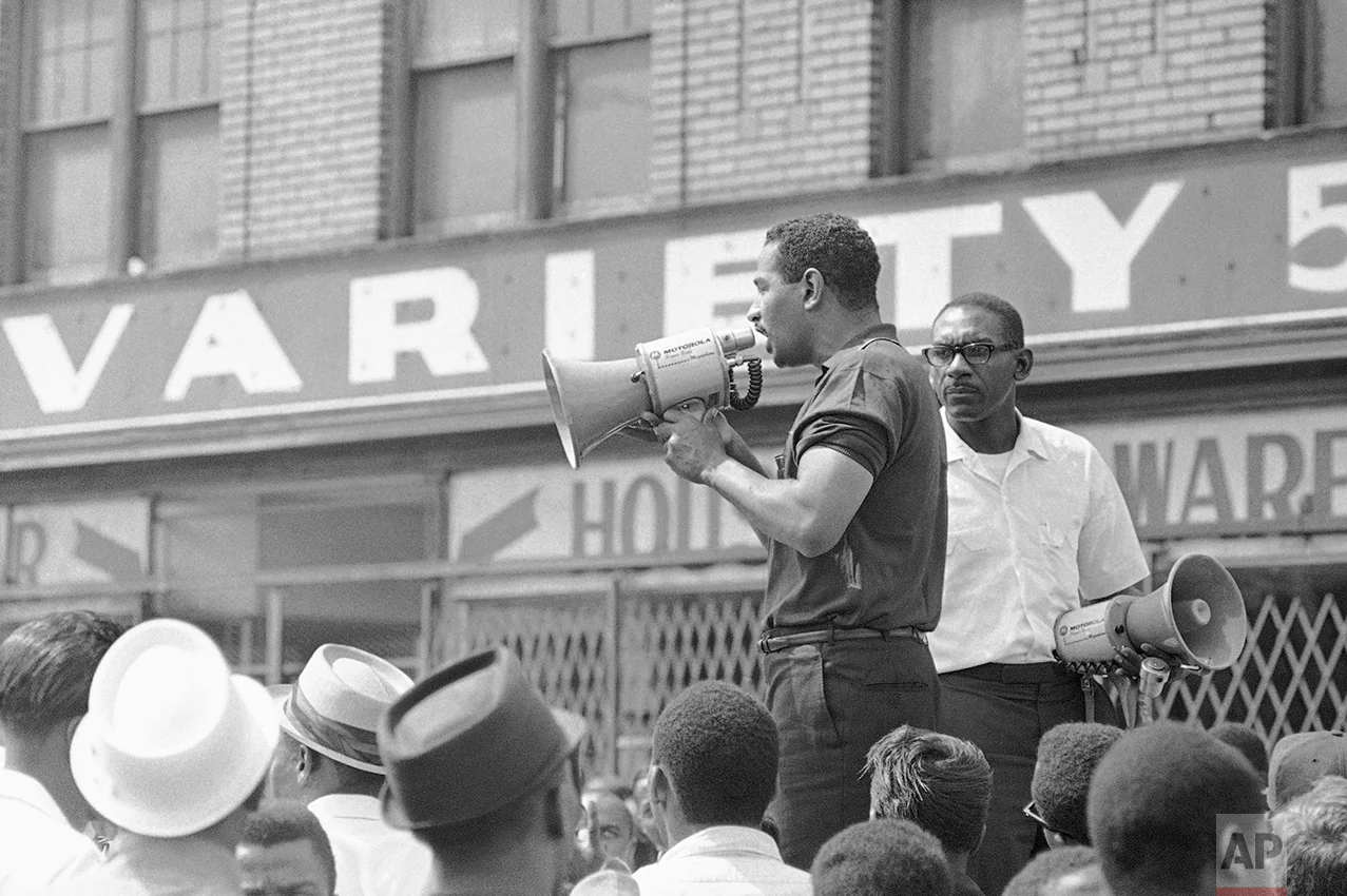 Congressman John Conyers, Detroit Democrat, uses a bullhorn as he tried to encourage African American in Detroit's riot area to go home, July 23, 1967. He was met with shouts of "No, no." As Conyers stepped down a rock hit the street a few feet from him. (AP Photo)