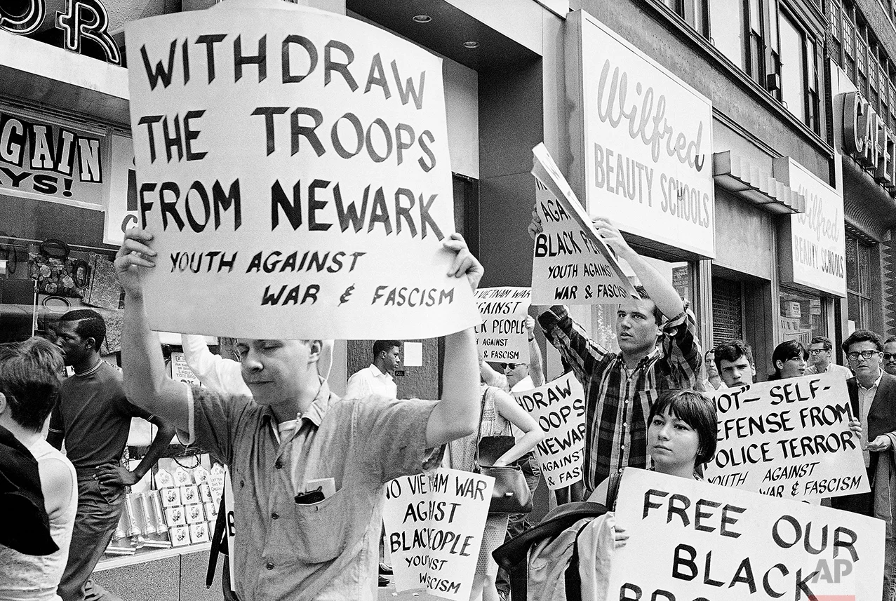 Pickets calling for the removal of National Guard troops from riot-ridden Newark march near Newark City Hall, July 16, 1967. Police arrived shortly after they began marching and dispersed the group. Marchers handed out handbills calling action against rioters full scale war. (AP Photo)
