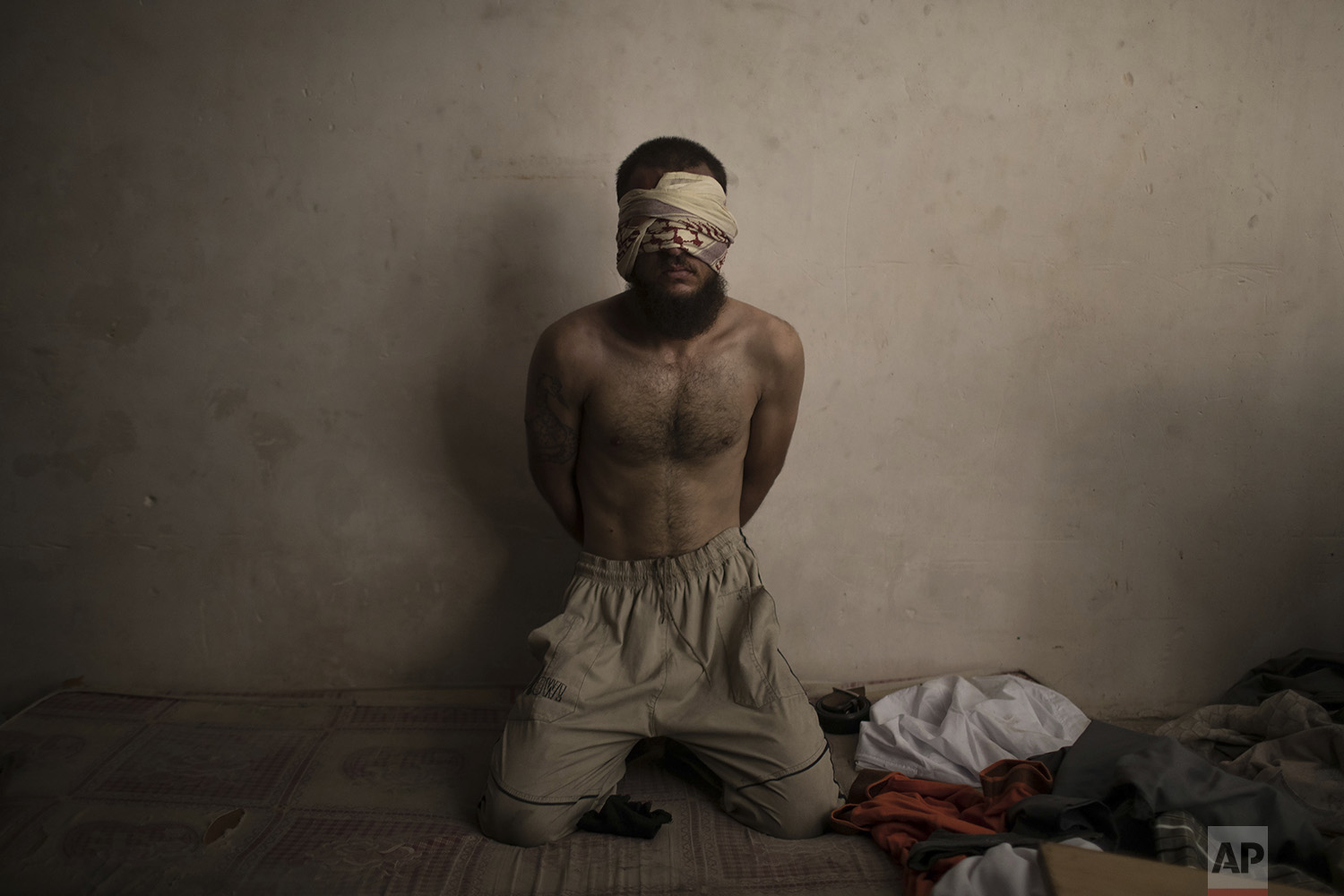 A suspected Islamic State fighter sits in a basement as Iraqi forces continue their advance against Islamic State militants in the Old City of Mosul, Iraq, Monday, July 3, 2017. (AP Photo/Felipe Dana)