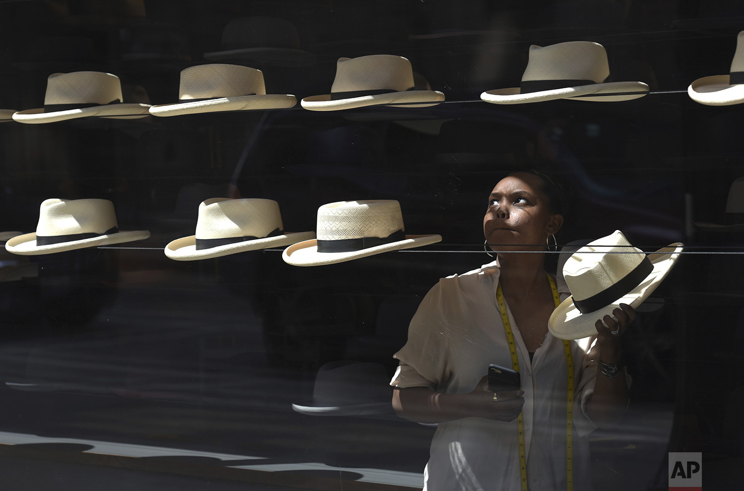 Late morning light illuminates Tiffany Bell as she works at a hat maker shop in downtown Chicago, Friday, July 7, 2017. (AP Photo/G-Jun Yam)