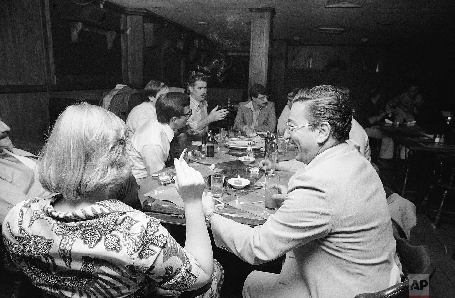  People in a midtown Manhattan bar keep drinking by candlelight in New York on Wednesday, July 13, 1977 after the city was struck by a power failure. (AP Photo/Steve Oualline) 