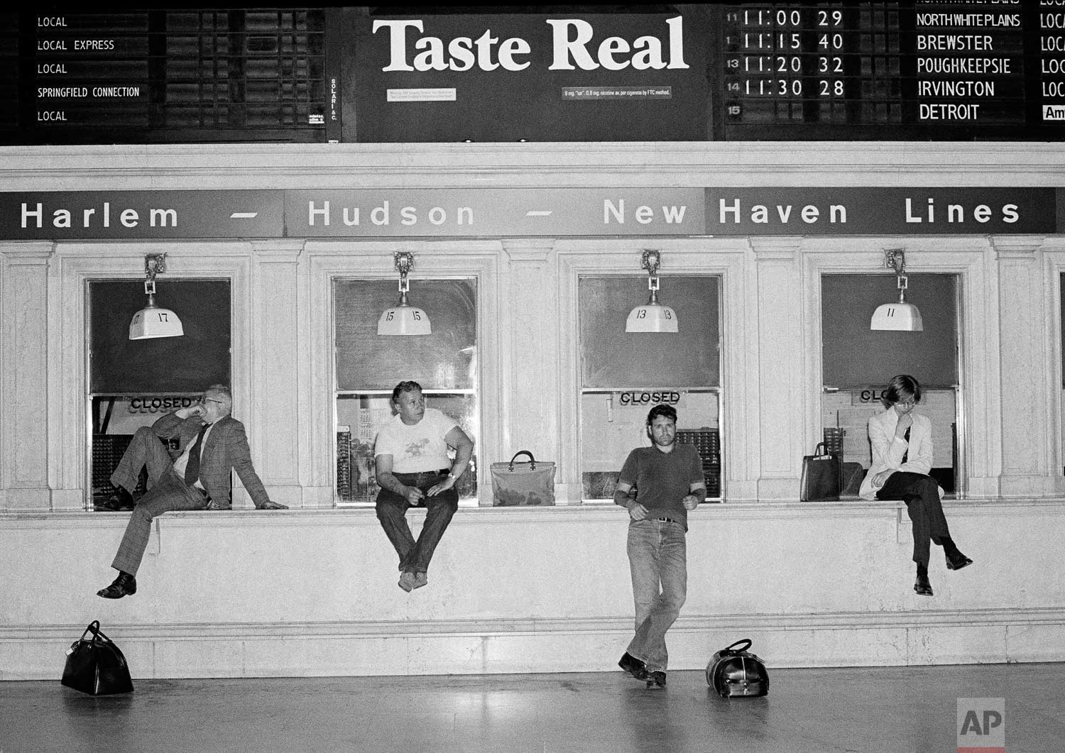  Commuters wait at empty ticket windows at Grand Central Station in New York City, early on July 14, 1977, as trains were canceled by the electric power failure that affected most public transportation in the city. (AP Photo/Carlos Rene Perez) 