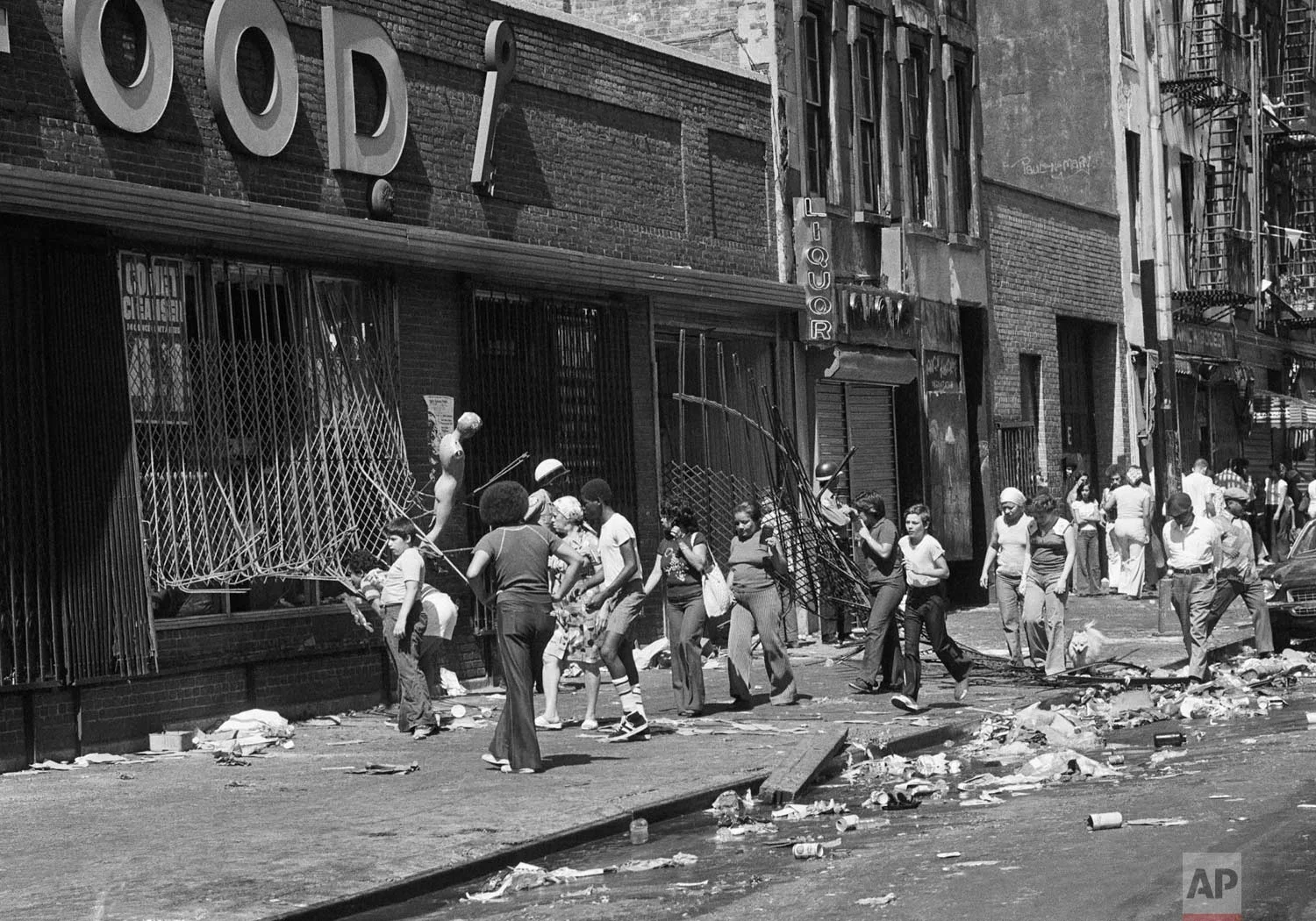 People peer into a looted store on 110th Street at Lexington Ave. in Manhattan the day after the power failure in New York, July 14, 1977. (AP Photo)