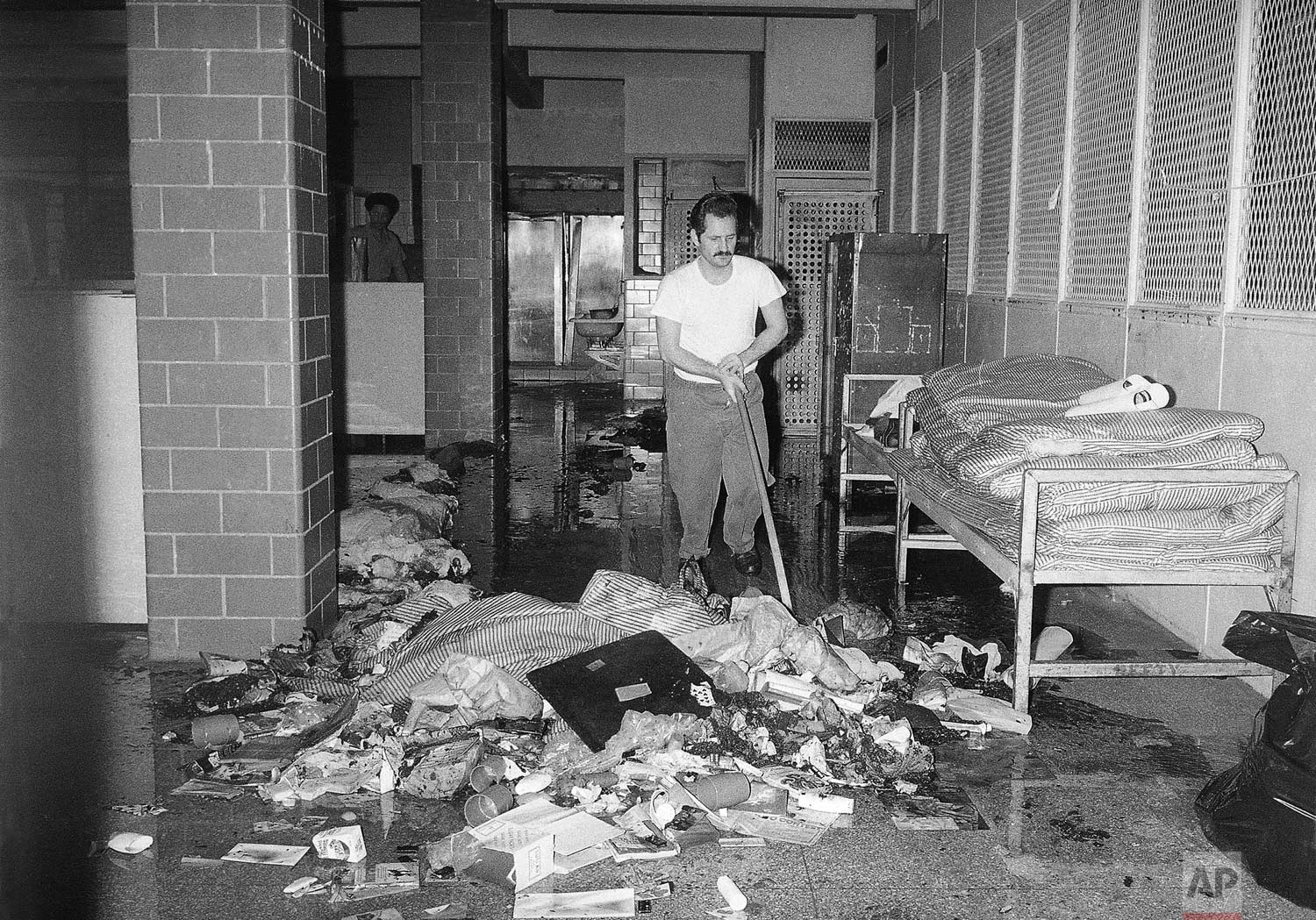  An inmate cleans up mess at the Bronx House of Detention in New York on Thursday, July 14, 1977. Corrections officials said inmates caused damage in three dormitories during the electric power failure that struck New York on Wednesday, July 13. (AP 