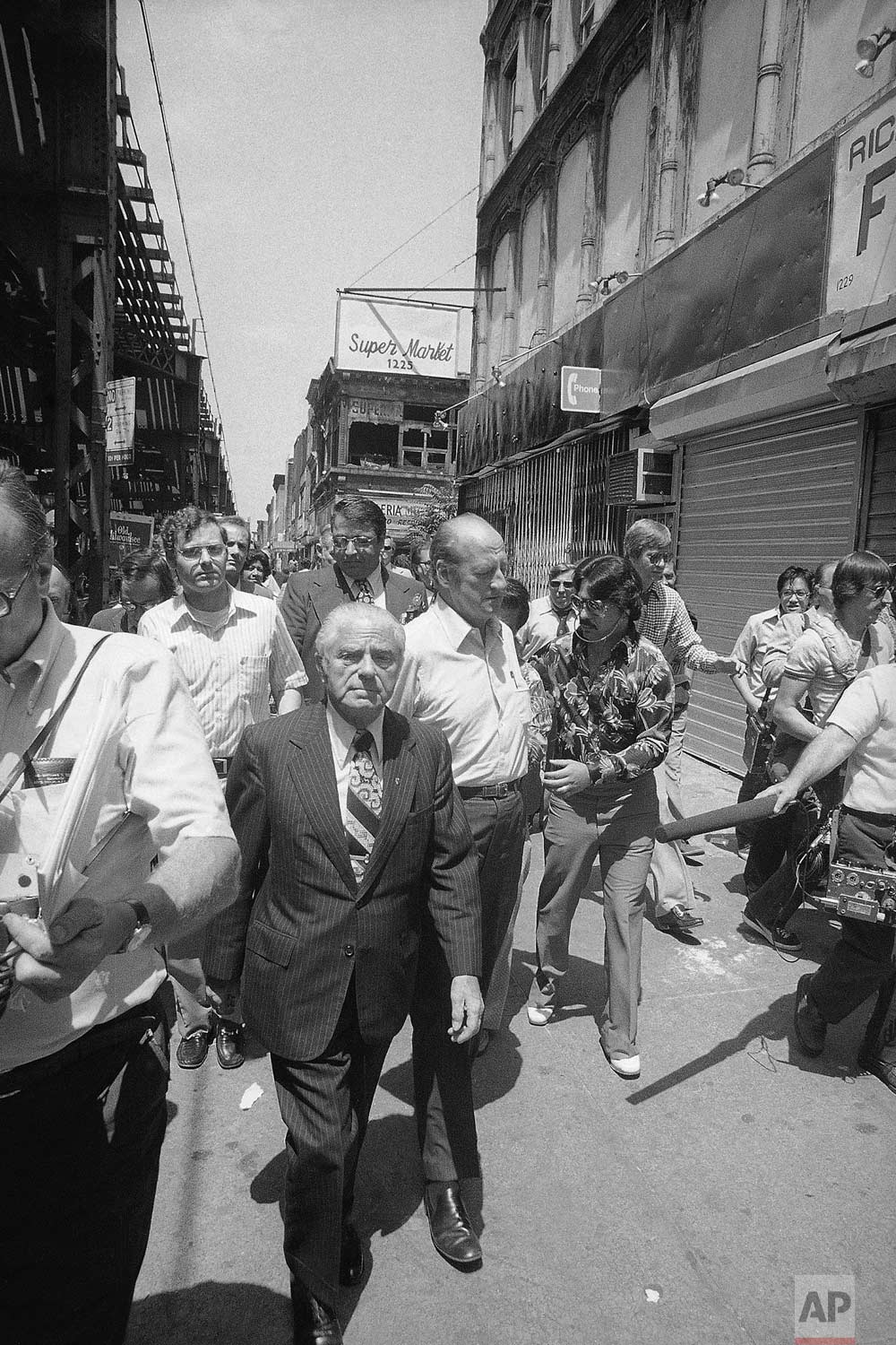  New York Mayor Abraham Beame, center, walks with shopkeepers and newsmen through looter-ravaged areas in New York's Bedford-Stuyvesant district on Friday, July 15, 1977. The area was one of the hardest hit by looters during Wednesday and Thursday's 