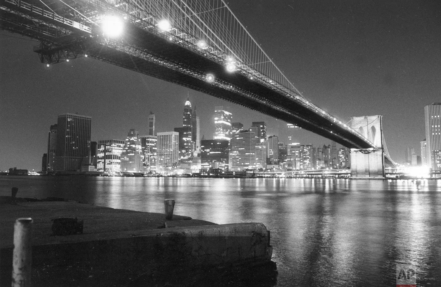  The lights of lower Manhattan shine across New York's East River in this nighttime view from under the Brooklyn Bridge on July 14, 1977.  Power has been restored in about 90 percent of the city, 24 hours after a city-wide electrical blackout.  (AP P