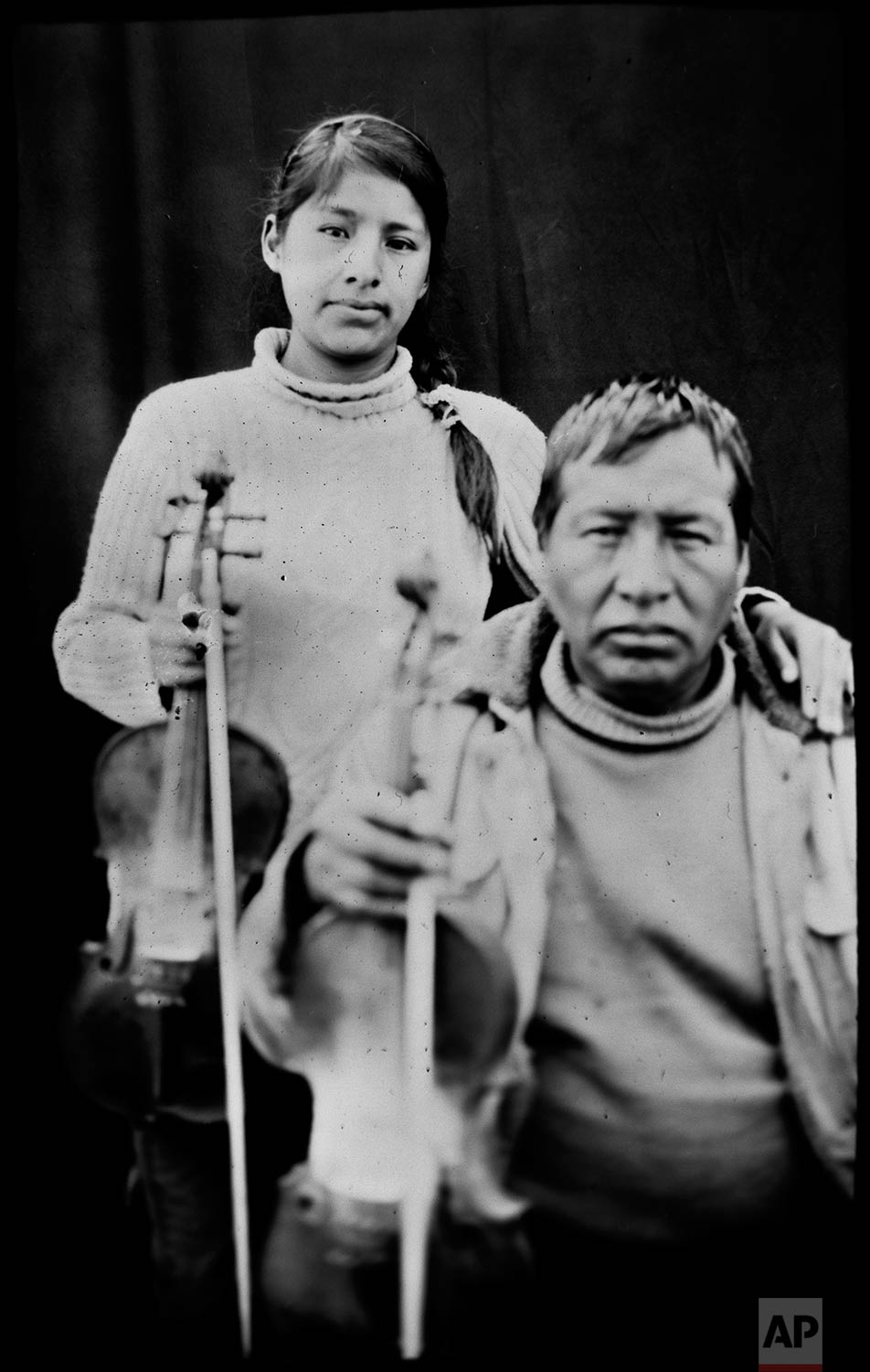 In this June 12, 2017 photo, Filament Wilca Soto, 54, his daughter Laura Wilca Quispe, 23, pose for a portrait in the Sinakara Valley, in Peru's Cusco region, during the Qoyllur Rit’i festival, translated from the Quechua language as Snow Star. Filament and Laura are violinists representing the Quispicanchis nation. (AP Photo/Rodrigo Abd)