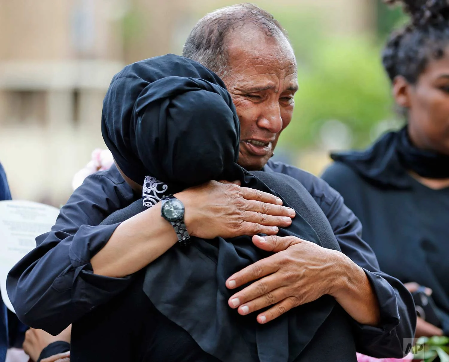 Mahmoud Hassanen Aboras, father of Nabra Hassanen, right, gets a hug from a supporter Wednesday, June 21, 2017, in Reston, Va., prior to the start of a vigil in honor of Nabar, who was killed over the weekend. Islamic leaders are questioning Virginia detectives' insistence that the beating death of Nabar appears to have been a case of road rage, saying the attack looks all too much like a hate crime. (AP Photo/Steve Helber)
