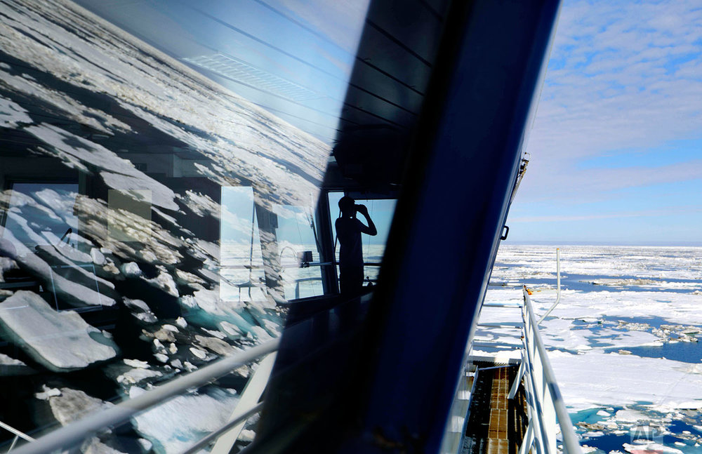  Trainee David Kullualik, of Iqaluit, Nunavut, of Canada's northern territories, looks through binoculars from the bridge of the Finnish icebreaker MSV Nordica as it sails through ice floating on the Chukchi Sea off the coast of Alaska while traversi