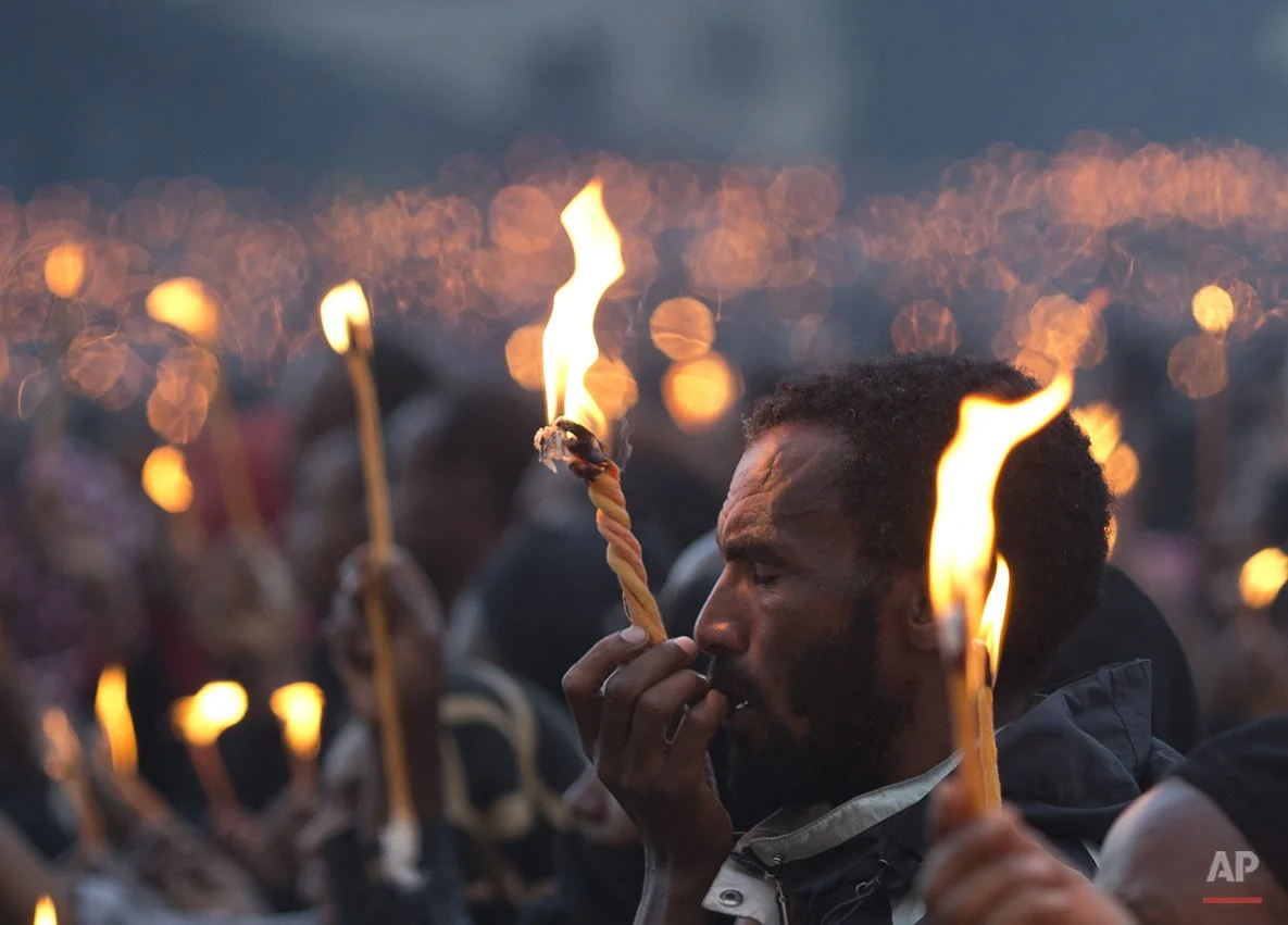  A man closes his eyes as he holds up his candle during a public candlelight memorial for late Prime Minister Meles Zenawi, at Meskel Square in Addis Ababa, Ethiopia Thursday, Aug. 30, 2012. Thousands turned out for the first of three days of planned